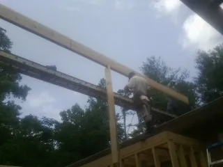 Carpenter setting a ridge beam over a new addition frame — Ice Dam Removal by Roofing Brothers in Venice